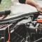 A person works on a vehicle's engine