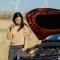 distressed woman with a broken down car calling emergency roadside assistance.jpg
