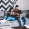 Couple in modern living room looking at laptop