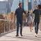 Family walking together on bridge with cityscape in the background