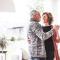 An older couple dance in the living room