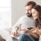 A man and a woman online shop together using a credit card