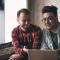 Two men sit and review their finances
