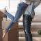 A man holds a woman up in the air in a big hug surrounded by moving boxes