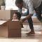 A father pushes his son around in a moving box