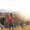 A older woman and man walk up a hill as the sun sets behind them