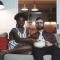 A couple sit on the couch and watch a movie with popcorn