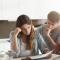 A young couple look overwhelmed calculating their bills