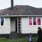 A wind damaged home with missing shingles and debris on the lawn