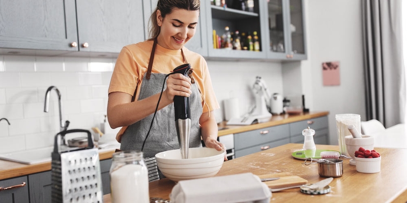 Woman blending while baking